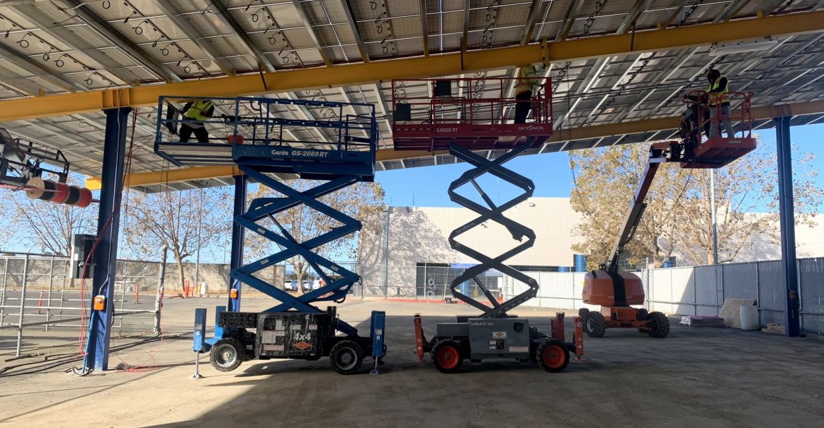 Cranes under the solar car port during construction. Cranes Under the Solar Car Port During Construction.